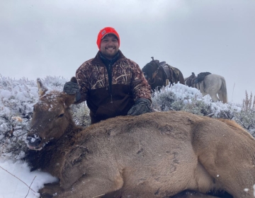 A happy hunter posing with his cow elk